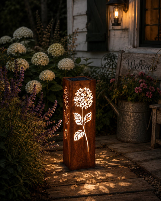 18 inch Hydrangea solar metal garden luminary with glowing floral cutouts in a cottage garden