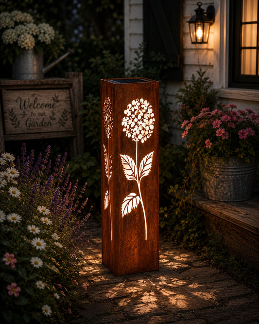 24 inch Hydrangea solar metal garden luminary with glowing floral cutouts in a cottage garden