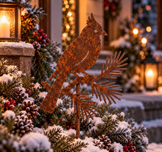 Rusted Woodland Winter Cardinal Metal Garden Stake featuring a crested bird perched on a pine branch, styled in a snowy porch planter with pinecones and red berries.